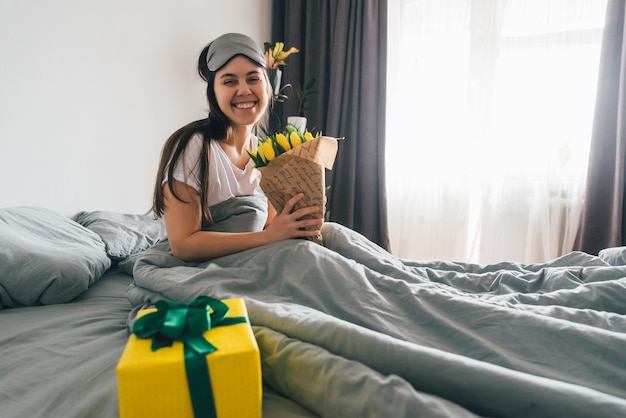 Vrouw blij om 's ochtends in bed romantisch concept te verrassen