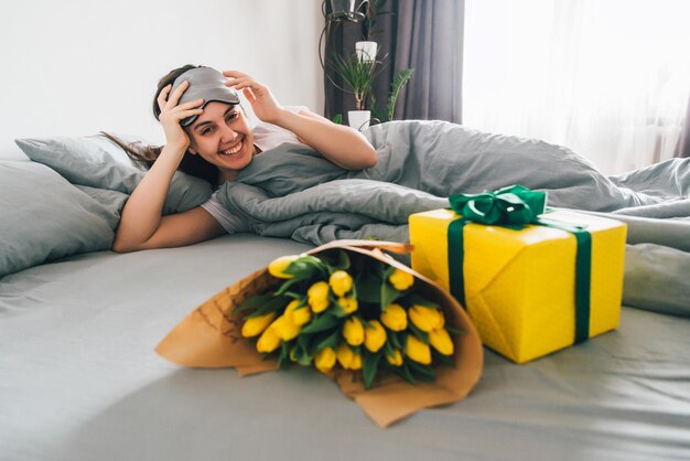 Vrouw blij om 's ochtends in bed te worden verrast. romantisch concept