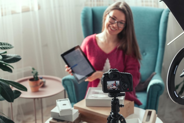 Foto vrouw blogger maakt video van gadgets thuis uitpakken