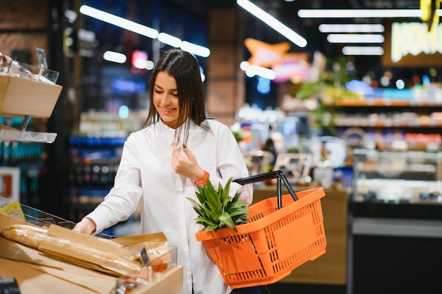 Vrouw boodschappen doet en ziet er heel gelukkig uit