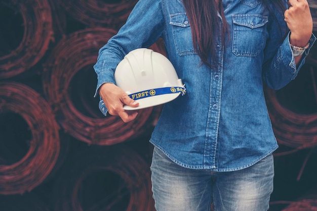 Vrouw bouwingenieur draagt een witte veiligheidshelm op de bouwplaats industriearbeider Vrouwelijke ingenieur arbeider civiele techniek met veiligheidshelm Vrouw bouwingenieur concept