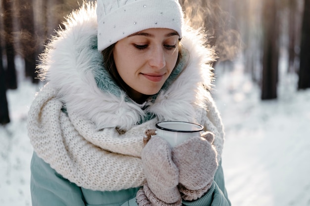 Vrouw buiten in de winter met een kopje thee