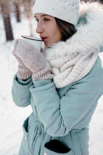 Foto vrouw buiten in de winter met een kopje thee