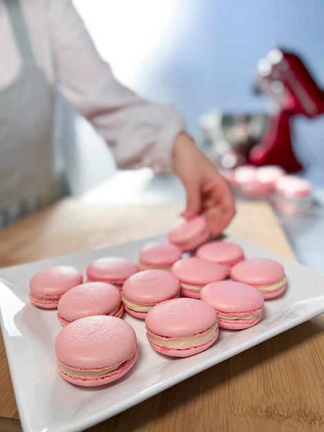 Vrouw chef-kok macarons maken Stockafbeelding