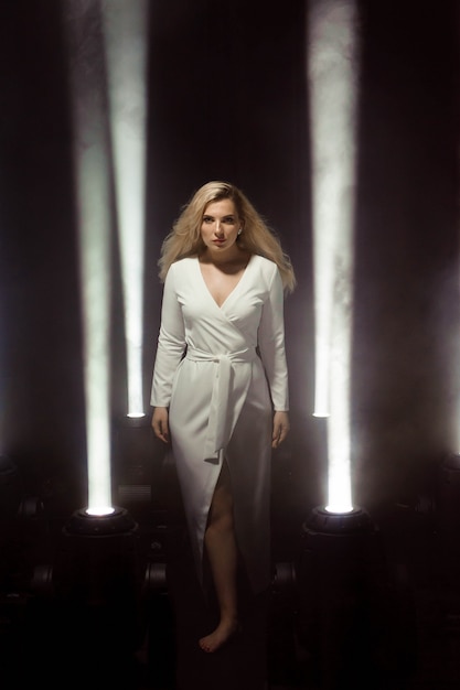 Vrouw clublicht partij Dansend meisje Lang haar. Plus size artiest poseren in een lichtstraal op het podium.