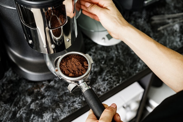 Vrouw coffeeshop werknemer koffie bereiden op professionele koffiemachine