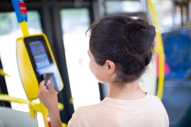 Vrouw contactloos betalen met smartphone voor het openbaar vervoer in de tram