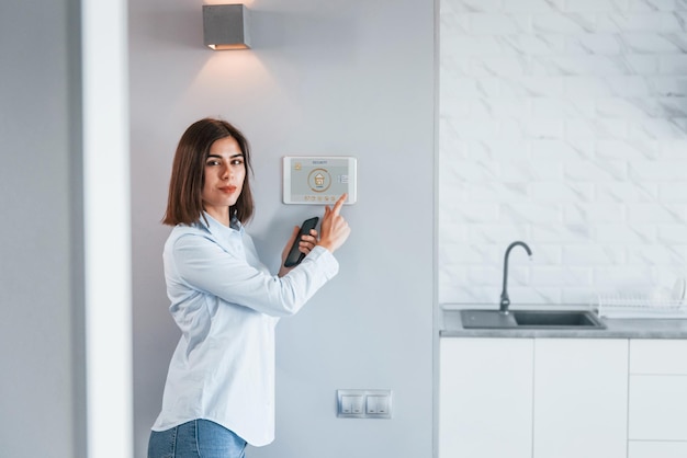 Vrouw controleert binnenshuis slimme huistechnologie