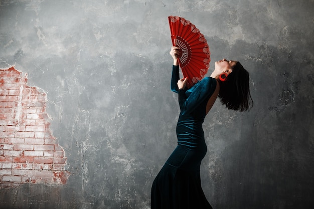 Foto vrouw danser flamenco dansen op grijze vintage studio achtergrond