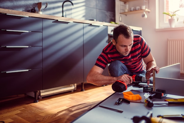 Foto vrouw de bouwkeuken en het gebruiken van een draadloze boor