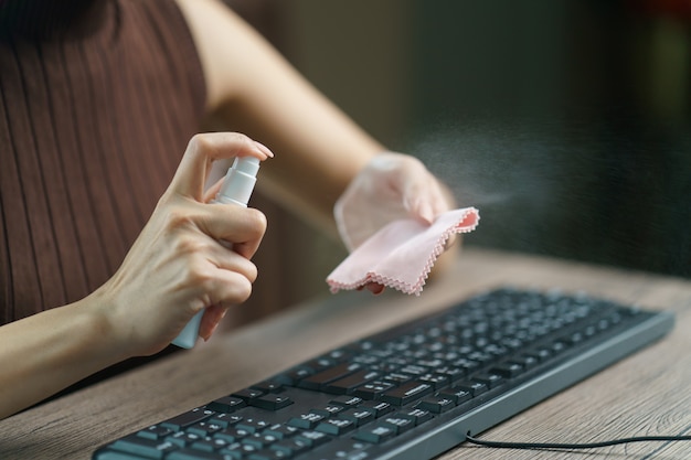 Vrouw desinfecterende apparaten thuis voor het voorkomen van ziekten