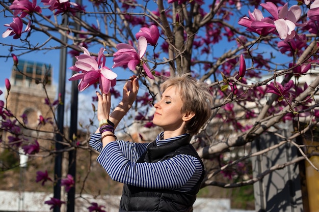 Vrouw dichtbij roze tulpen bloeiende boom