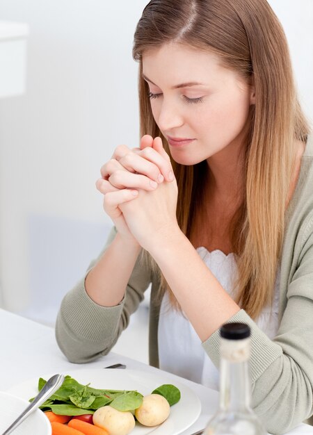 Vrouw die aan de tafel bidt