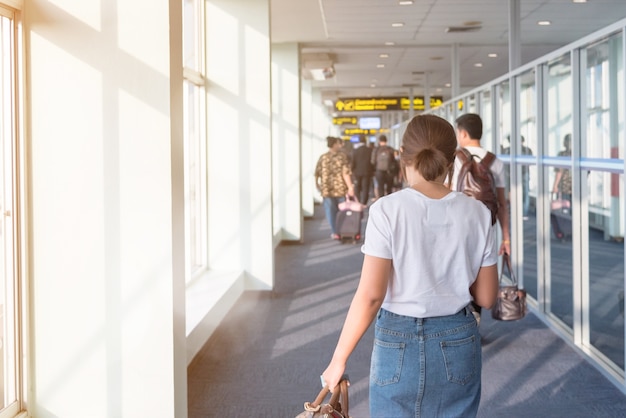 Vrouw die aan het vliegtuig bij vertrekgang lopen in de luchthaven