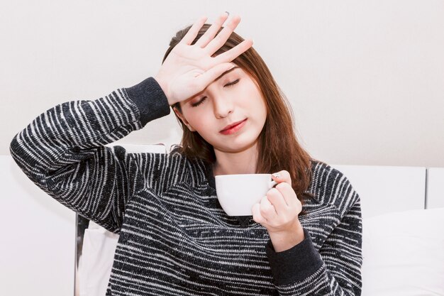 Vrouw die aan hoofdpijn thuis lijdt