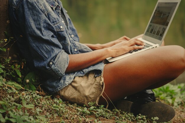 Vrouw die aan laptop in de aard werkt