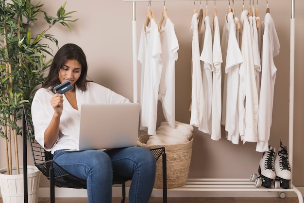 Vrouw die aan laptop naast garderobe werkt