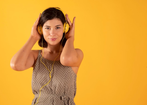 Vrouw die aan muziek met gele hoofdtelefoons luistert