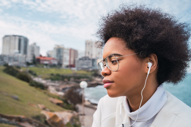 Vrouw die aan muziek met oortelefoons luistert.