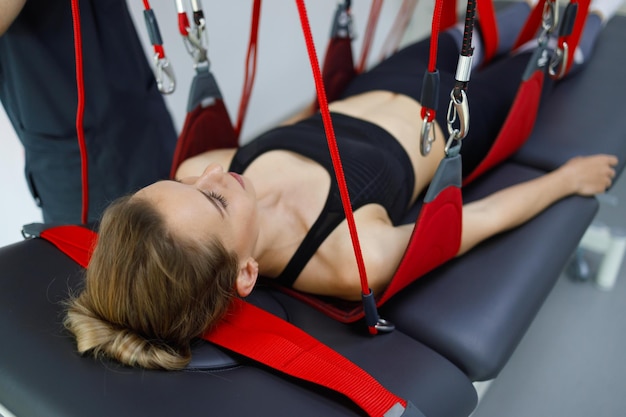 Vrouw die aan rode touwen hangt tijdens een neuromusculaire activeringsprocedure