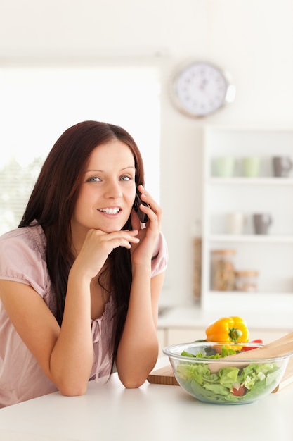 Vrouw die aan tafel telefoneert