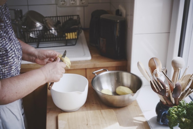 Vrouw die aardappelen schilt