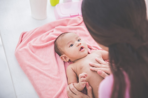 Vrouw die babylotion op haar baby toepast