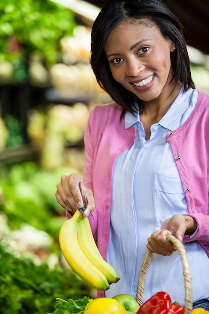 Vrouw die banaan in organische sectie koopt