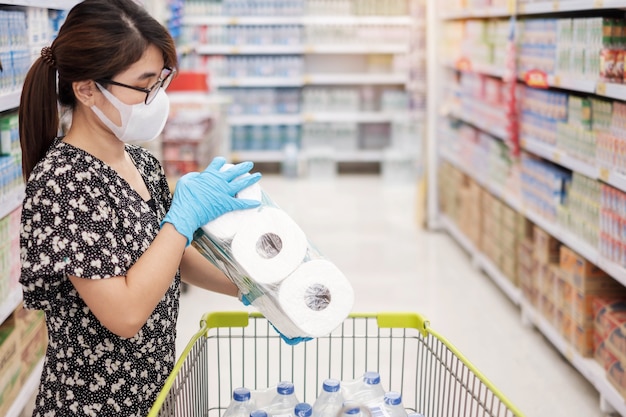 Vrouw die beschermend masker draagt en toiletpapier houdt