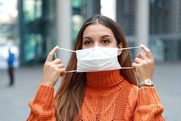 Foto vrouw die beschermend masker op gezicht in stadsstraat draagt