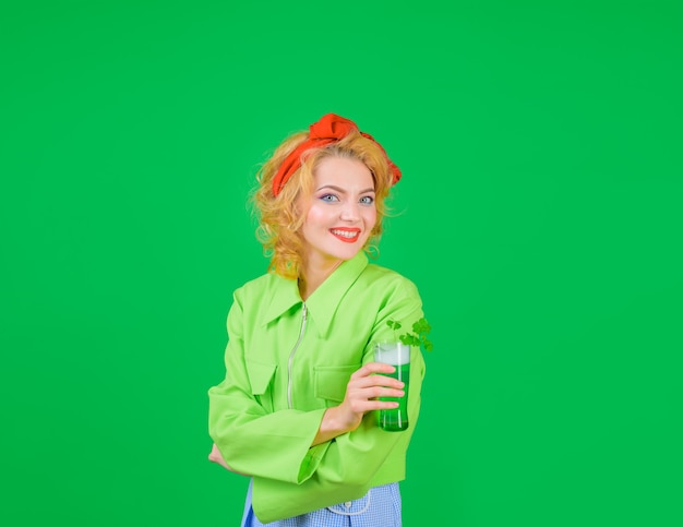 Vrouw die bier drinkt in de kroeg heilige patricks dag st patricks dag glimlachende vrouw houdt glas met groen vast