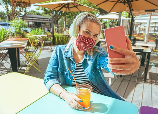 Vrouw die bij bar een selfie met gezichtsmasker neemt