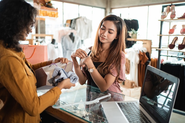 Vrouw die bij boutiqueopslag winkelen in mal