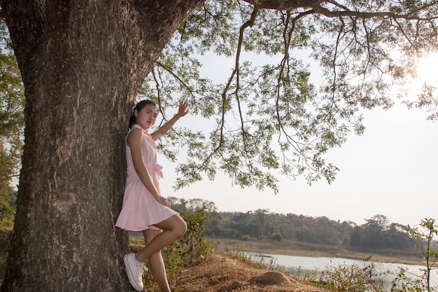 Foto vrouw die bij de boomstam staat