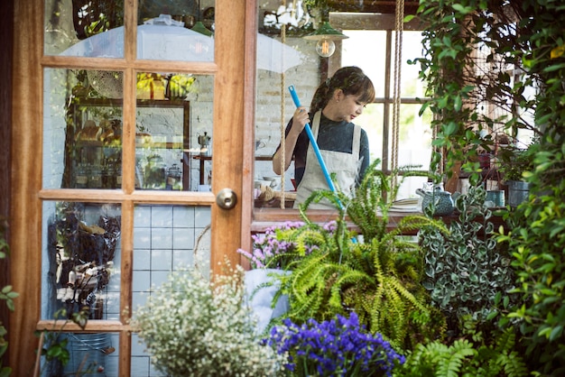 Vrouw die binnen haar bloemwinkel opruimt