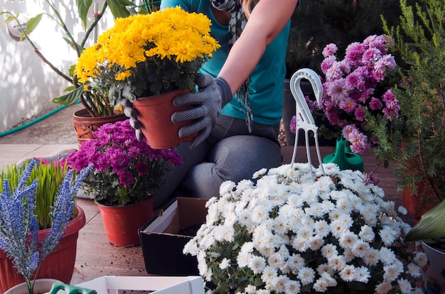 Vrouw die bloemen in terrastuin plant