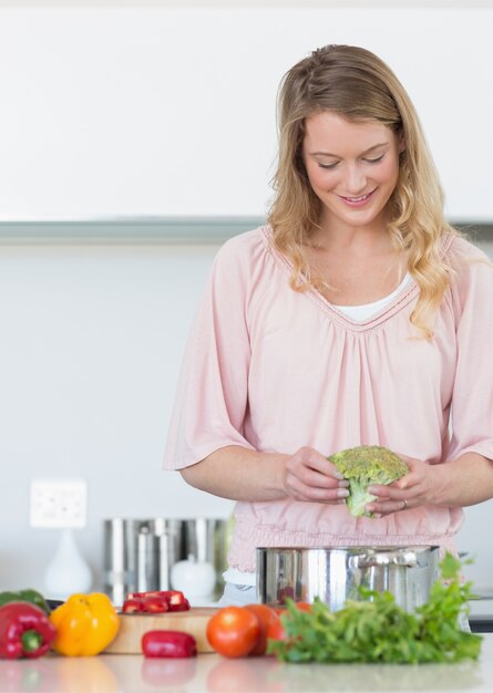 Vrouw die broccoli in keuken voorbereidt