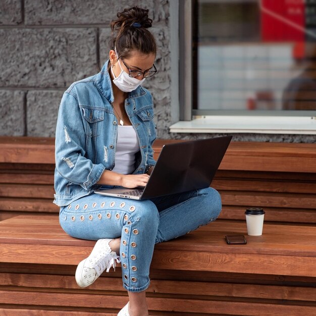 Foto vrouw die buiten een laptop gebruikt