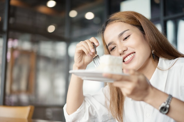 Vrouw die cake eet bij dessertkoffie.