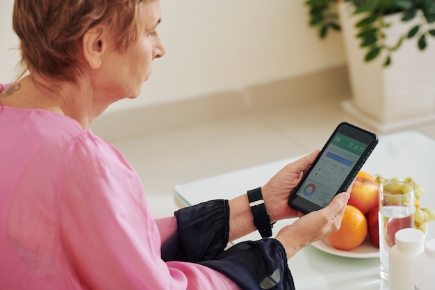 Vrouw die calorieteller controleert