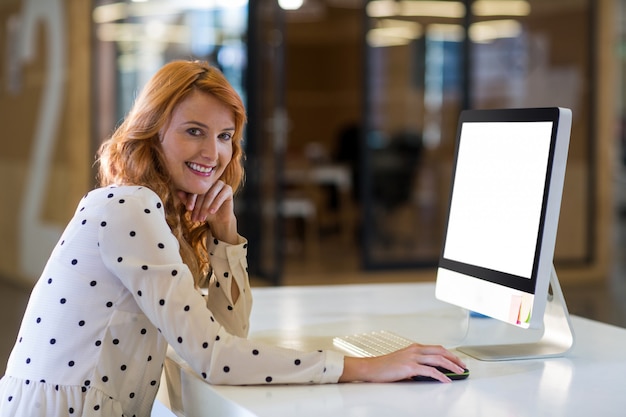 Vrouw die computer in bureau met behulp van