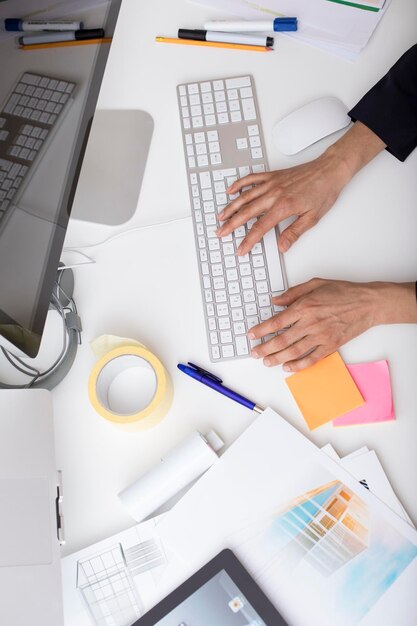 Vrouw die computertoetsenbord gebruikt bij bureau in bureau