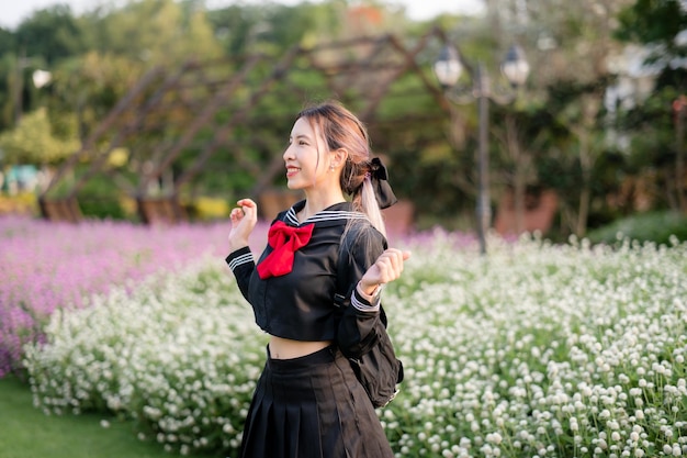 Vrouw die cosplay Japans schooluniform draagt bij park openlucht