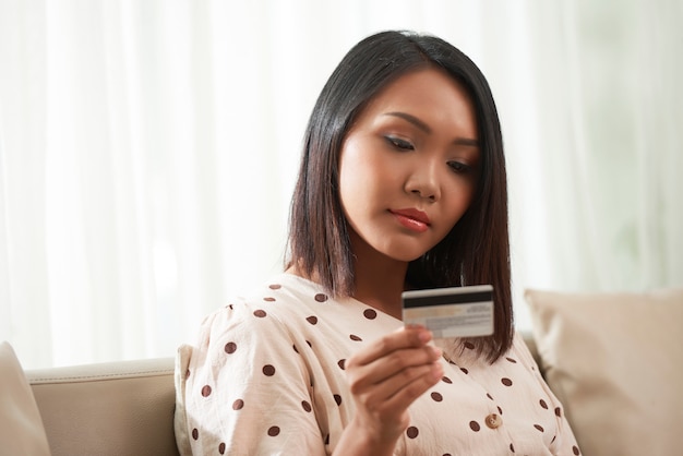 Vrouw die creditcard onderzoekt