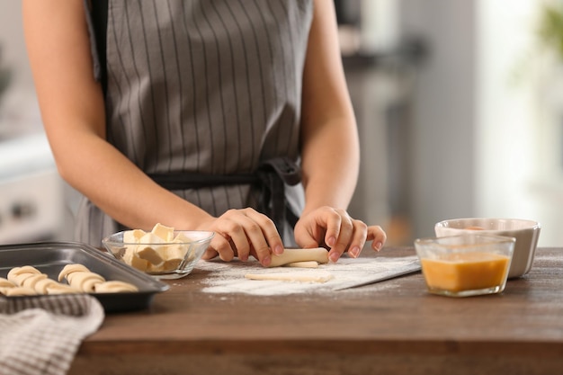 Vrouw die croissants in keuken voorbereidt