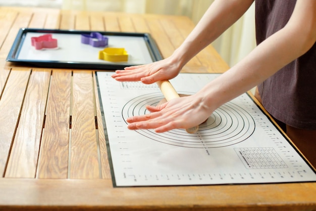 Vrouw die culinaire siliconenmat gebruikt voor het koken van zelfgemaakt bakken