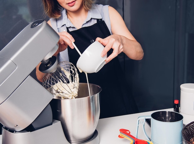 Vrouw die de cakemachine van de mixerbakkerij maakt