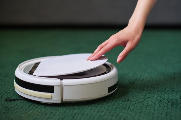 Vrouw die de robotstofzuiger aanzet