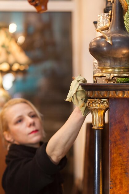 Foto vrouw die decoraties schoonmaakt.