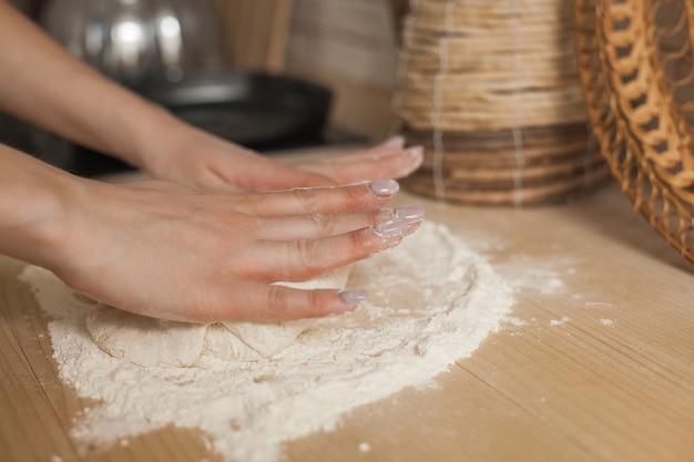 Vrouw die deeg maakt. Vrouw koken. Chef-kok gebak maken. De handen van de close-upvrouw `s met bloem en het deeg.